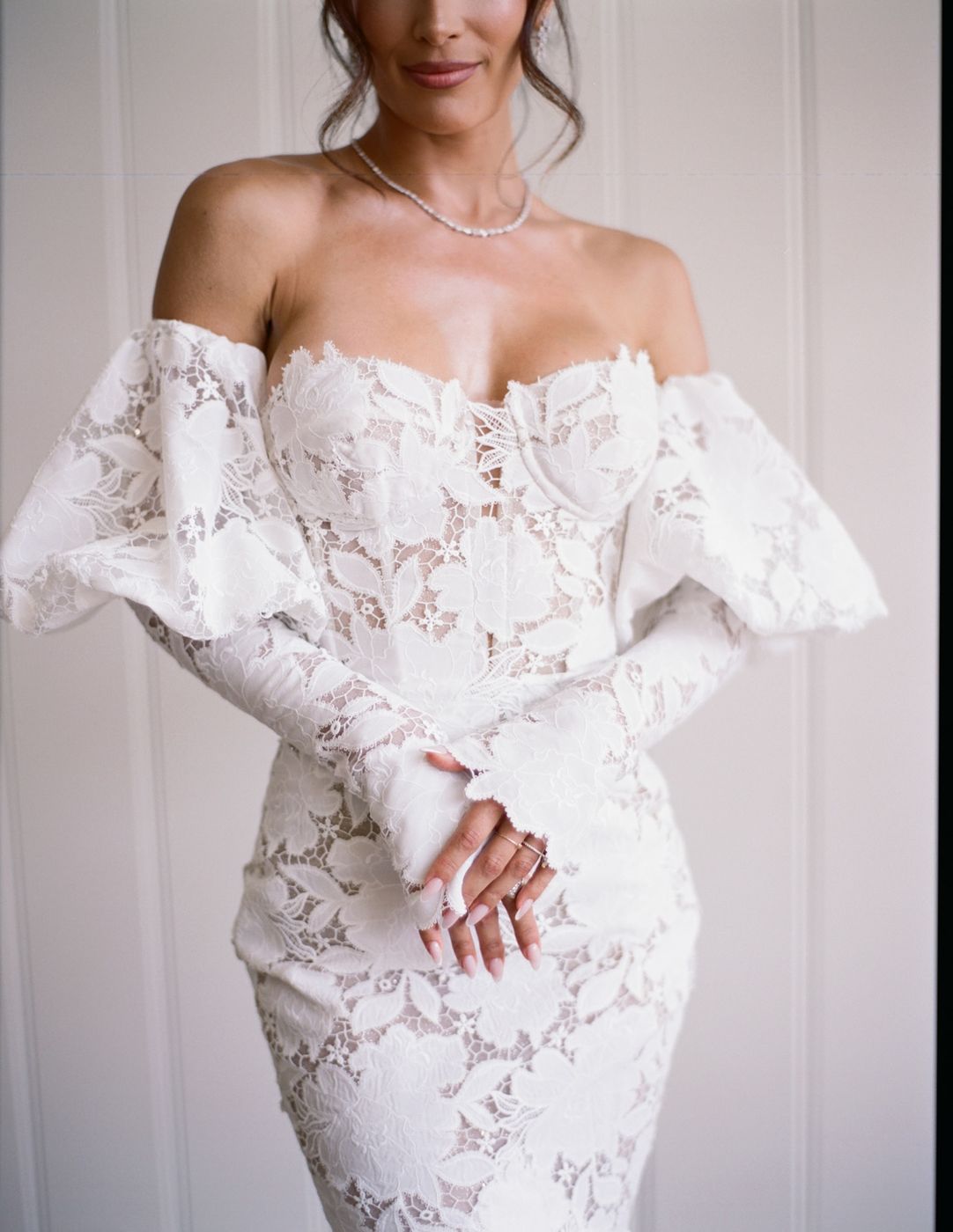 Bride in an off-the-shoulder lace gown with a pearl necklace